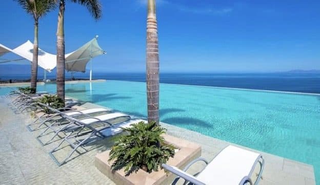The infinity pool through palms