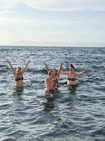 A woman standing with her arms open to the ocean