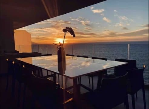 A long table set for dinner as the sun goes down