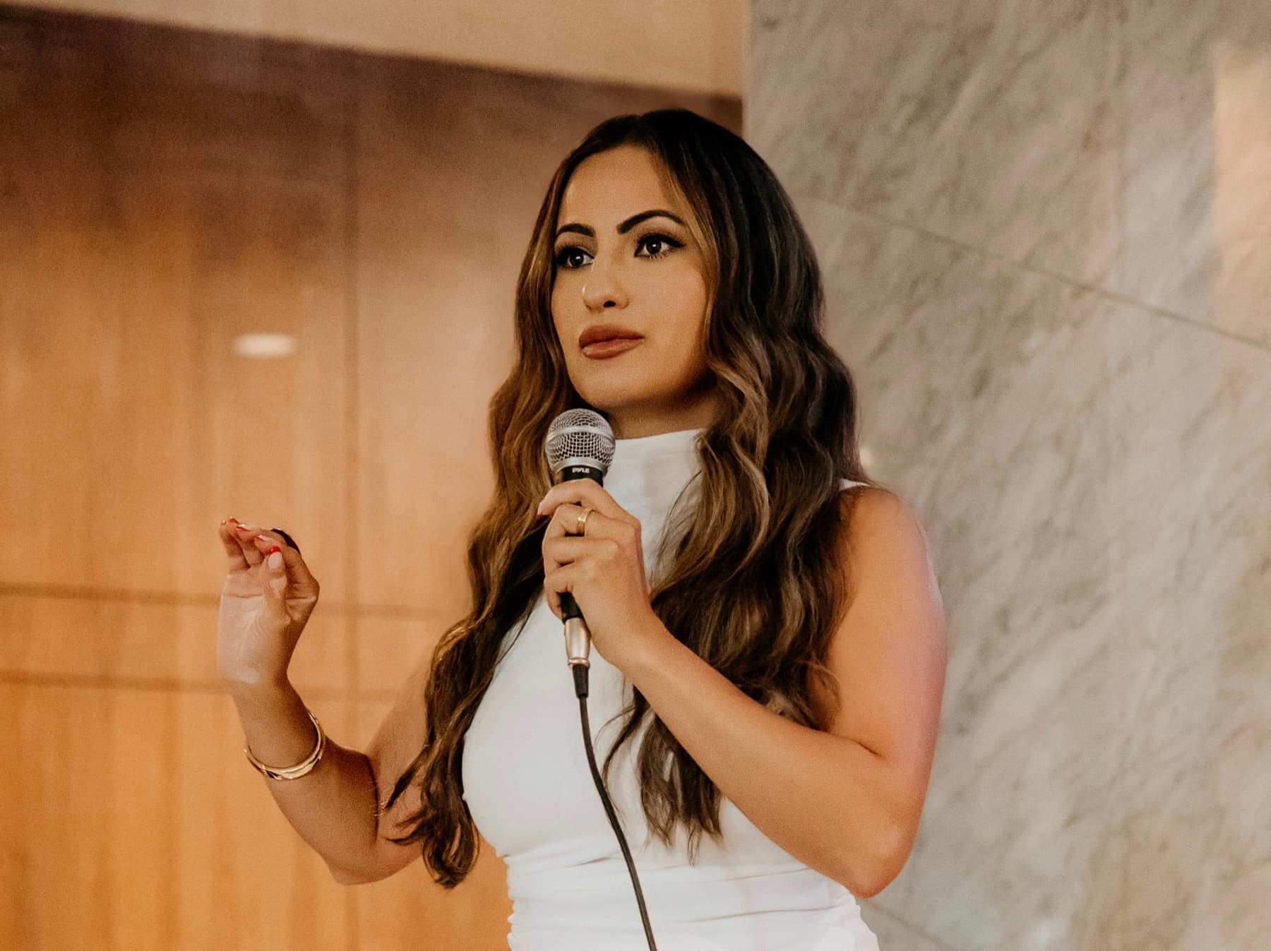 Hevi Serdar mid-sentence with a handheld microphone